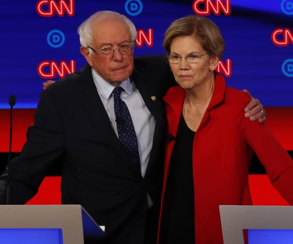 elizabeth warren and bernie sanders stand arm in arm