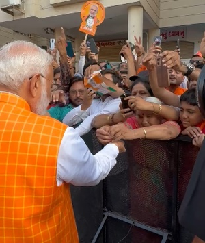 Woman Ties Rakhi to PM Modi as Huge Crowd Gathers outside Polling Booth in Ahmedabad