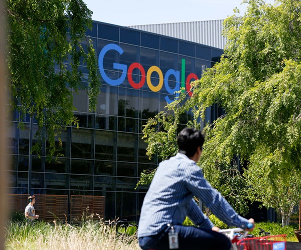 a man rides a bike on google's main campus