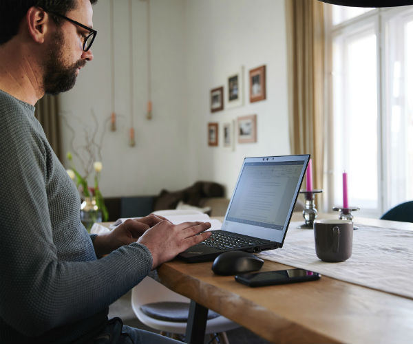 a man is shown working on his laptop from home