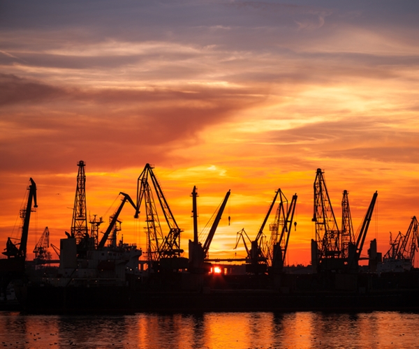 cargo ships in harbor amid sunset