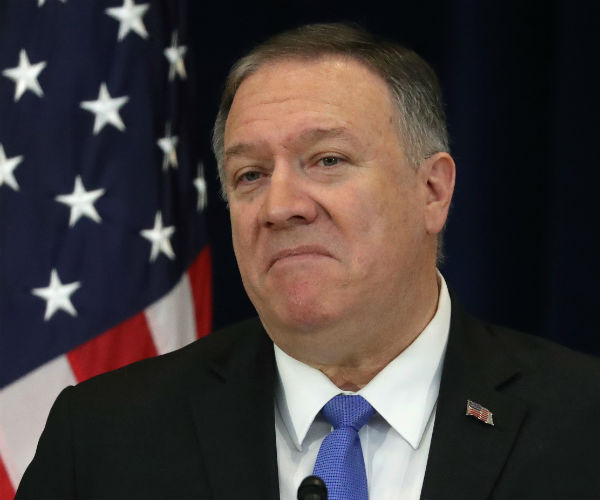 mike pompeo is shown with the us flag in the background