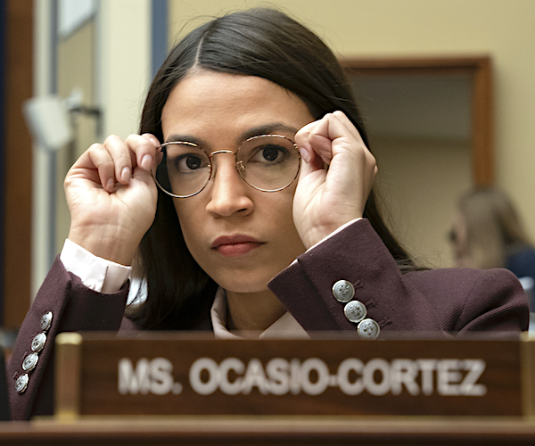 alexandria ocasio-cortez adjusts her glasses during a house committee hearing