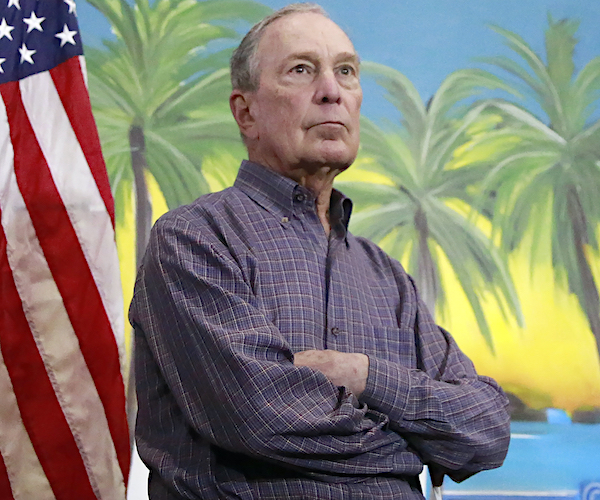 mike bloomberg stands with his arms folded on the last night of his campaign