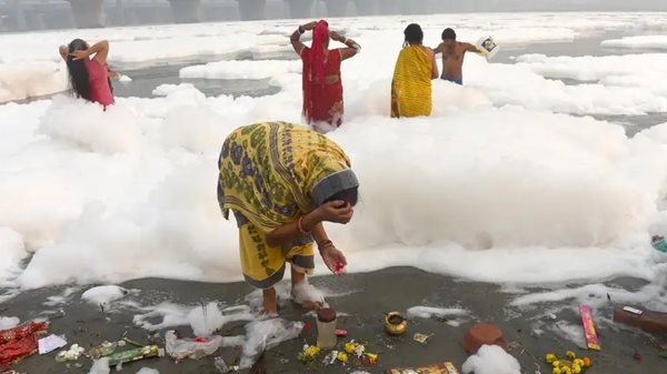Devotees in Delhi celebrate Chhath Pooja in toxic foam covered sacred Yamuna river